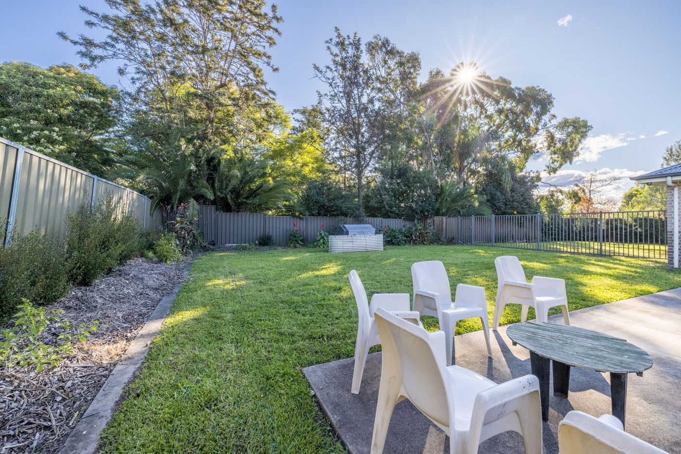 Backyard on-a-sunny-day-with-garden_-grass-area-and-outdoor-seating