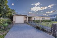 Front of-home-on-a-sunny-day-with-view-of-the-driveway-and-front-garden-and-grass-area